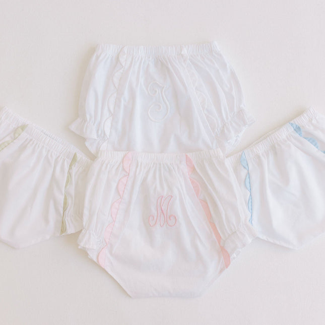 Set of white diaper covers with colorful accents on a light gray background