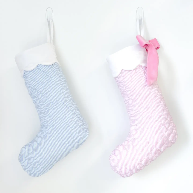 Two baby socks, one blue and one pink with a bow, on a white background.