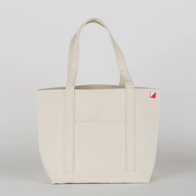 Natural tote bag with a small red logo on a light gray background