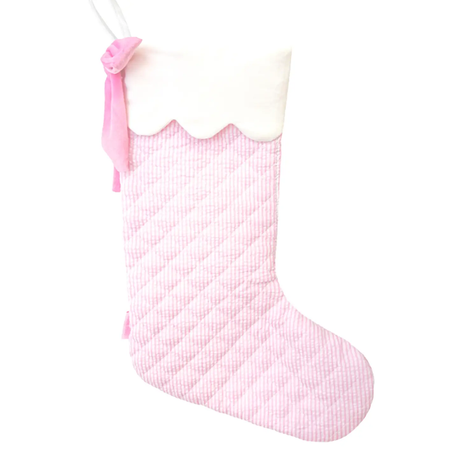 Pink and white checkered Christmas stocking with a pink bow on a white background