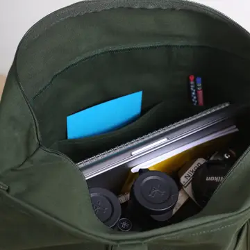 Green bag with camera equipment and a blue card inside